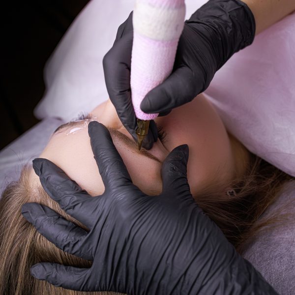 Side view of the work performed by a master of permanent eyebrow makeup. PMU Procedure